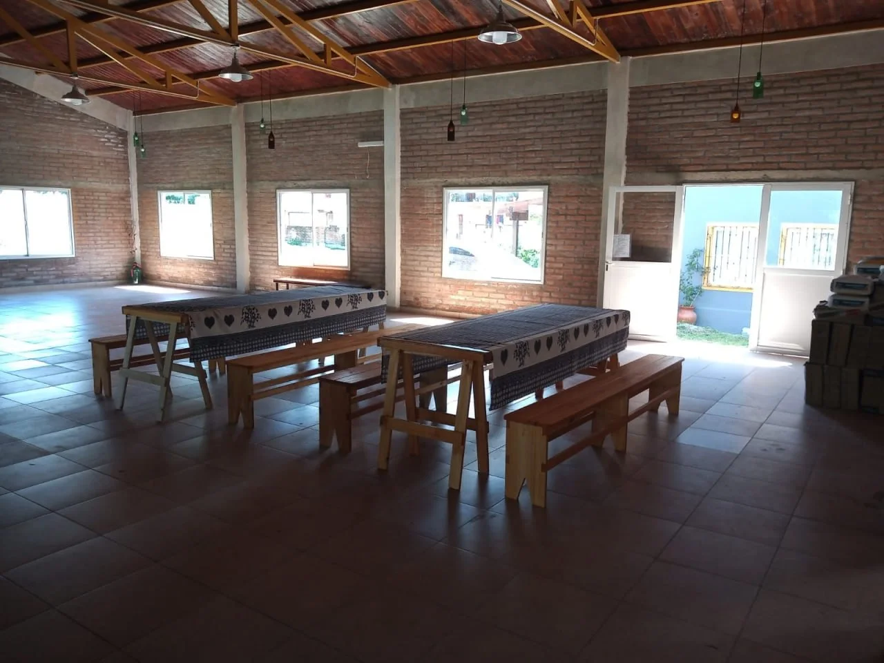 Salón amplio con mesones y bancos de madera